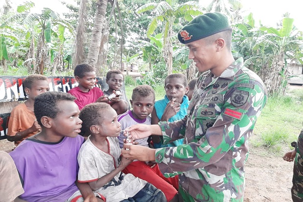 Penuh Kesabaran, Prajurit Kostrad Ajak Anak Papua Minum Susu