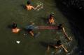 Keceriaan Anak-Anak Menghabiskan Waktu dengan Berenang di Kali Krukut