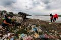 Gunakan Masker, Warga Bersih-bersih Pantai Tanjung Kait