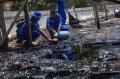 Petugas Dit Polair Polda Kepri Bersihkan Limbah Minyak Hitam di Pantai Batam
