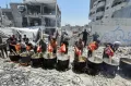 Potret Warga Palestina Menikmati Makanan di Tengah Reruntuhan